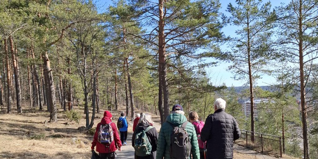 Luontohengähdys-hankkeen retki Lahteen. Kuvassa henkilöt kävelevät polkua pitkin selkä kameraan päin.